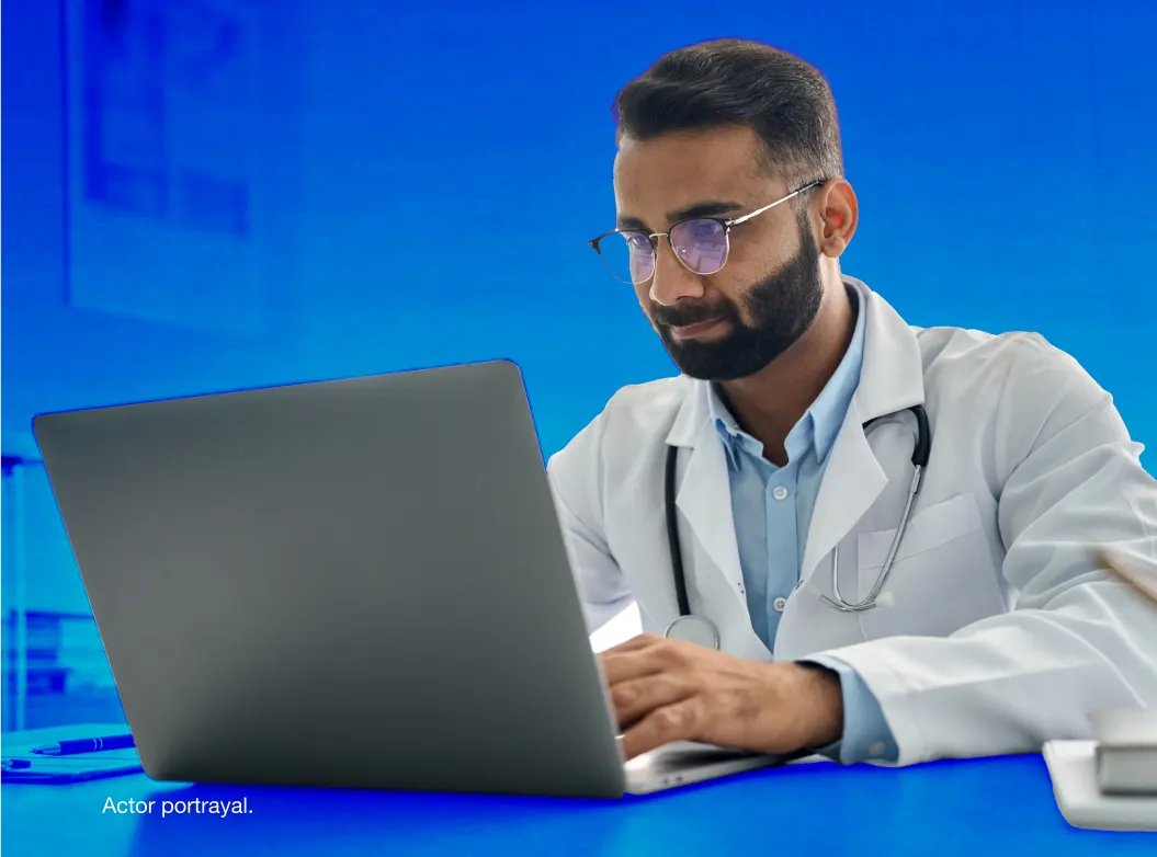 A male doctor staring intently at his computer