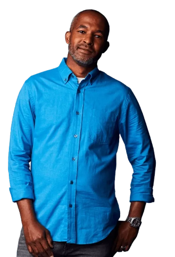 A middle aged man wearing a blue shirt and looking at the camera with a hopeful expression